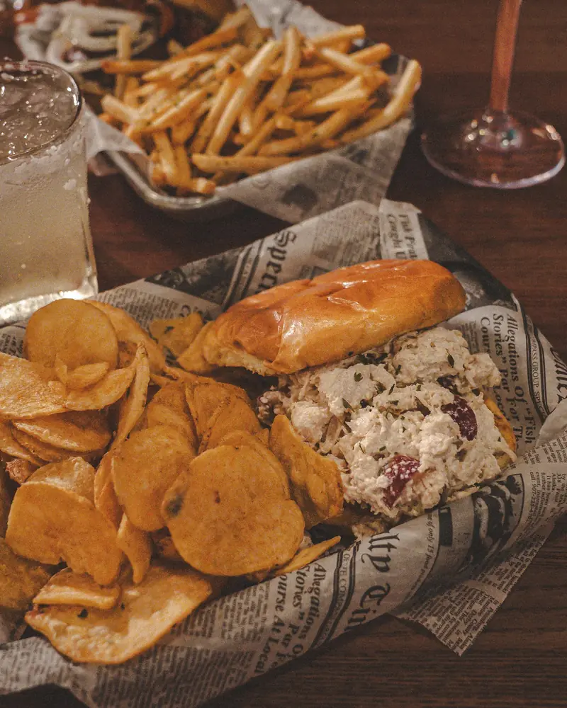 A chicken salad sandwich on a brioche bun with house-made chips