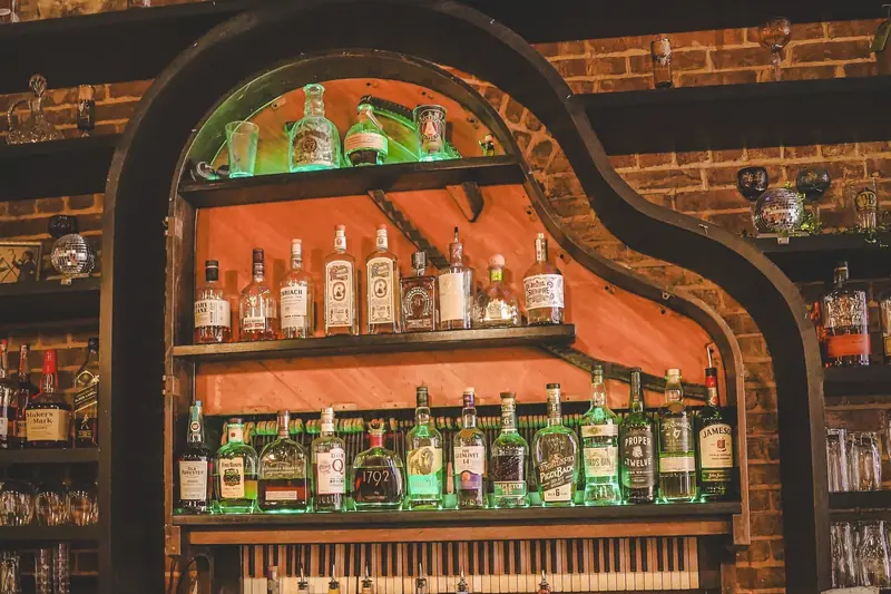 The piano-shaped back bar, bottles lined up along its shelves above the keys